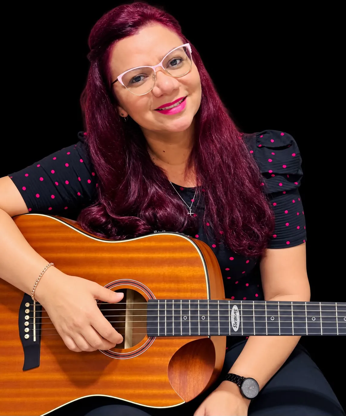 Cristiane Araujo, fundadora da Be Blessed Idiomas, sorrindo com um violão